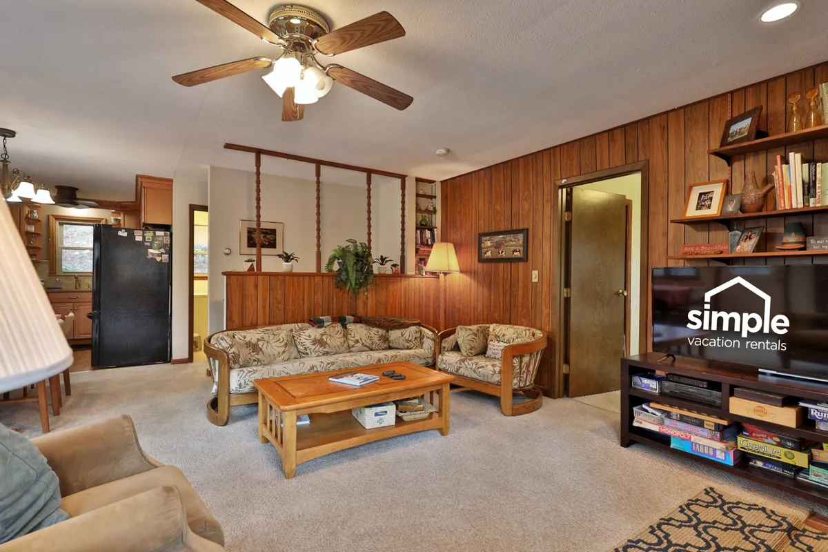 A welcoming family room with a comfortable sofa, coffee table, television, and bookshelf, arranged for easy conversation and relaxation. The layout is ideal for family gatherings, game nights, or curling up with a good book in a warm ambiance.